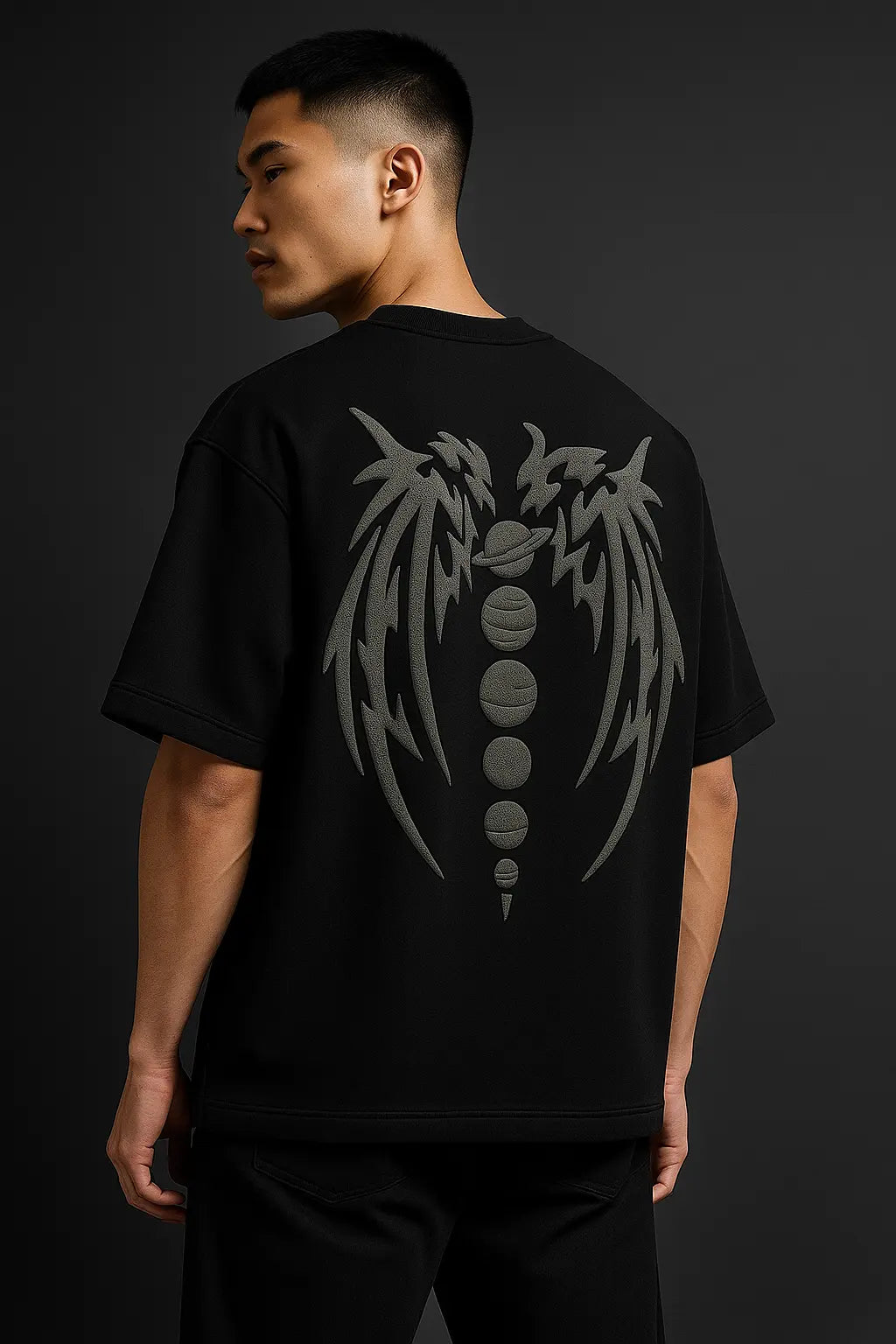 Model wearing oversized Astral Rift tee with grey puff print wings graphic on back, showcasing premium cotton fabric.